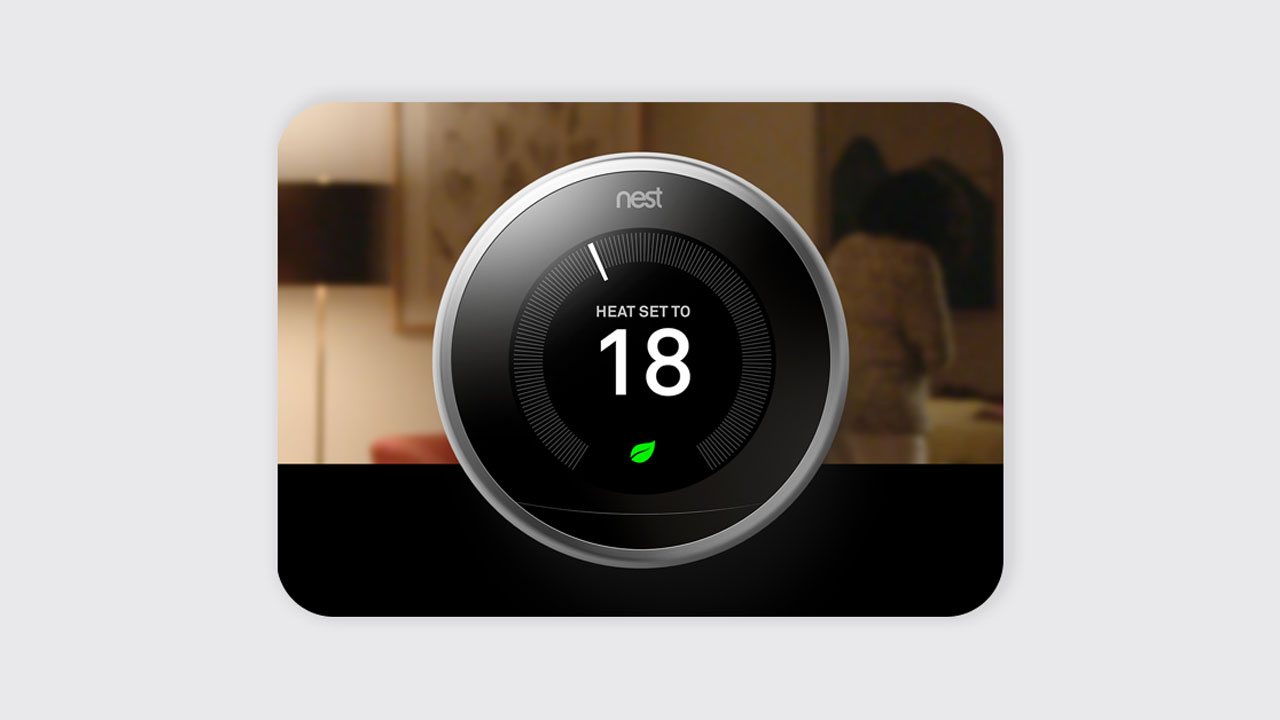 Google Nest Learning Thermostat controlling home temperature with remote access through a smartphone app.