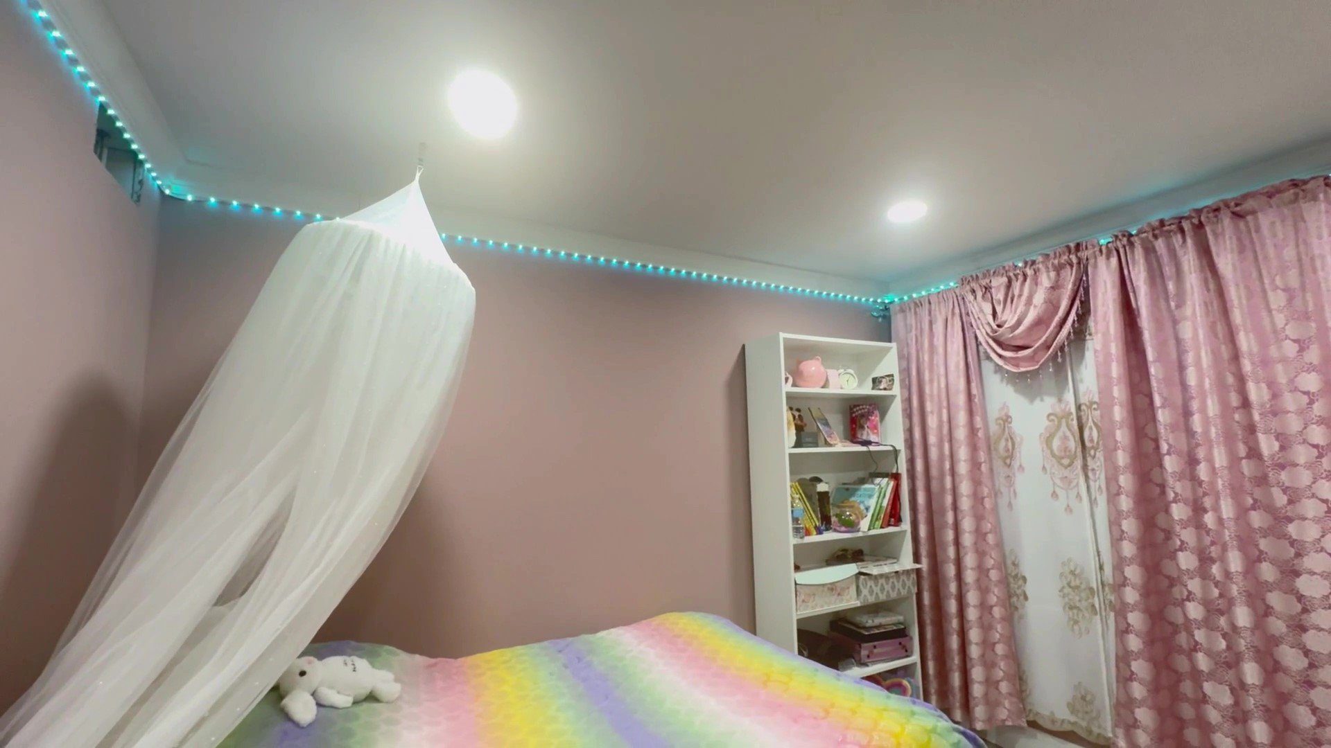 100ft LED strip lights with music sync feature illuminating a modern bedroom.
