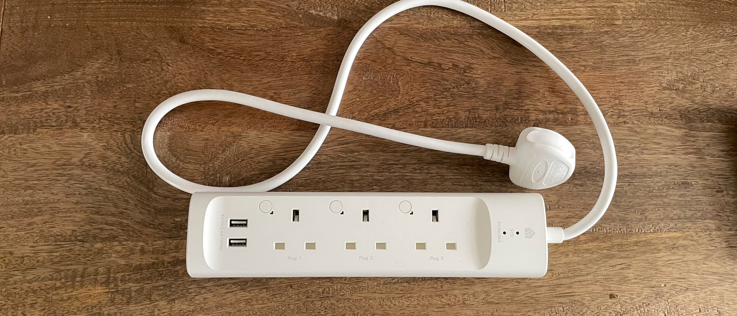 Kasa Smart Power Strip KP303 with 3 individually controlled outlets on a desk.