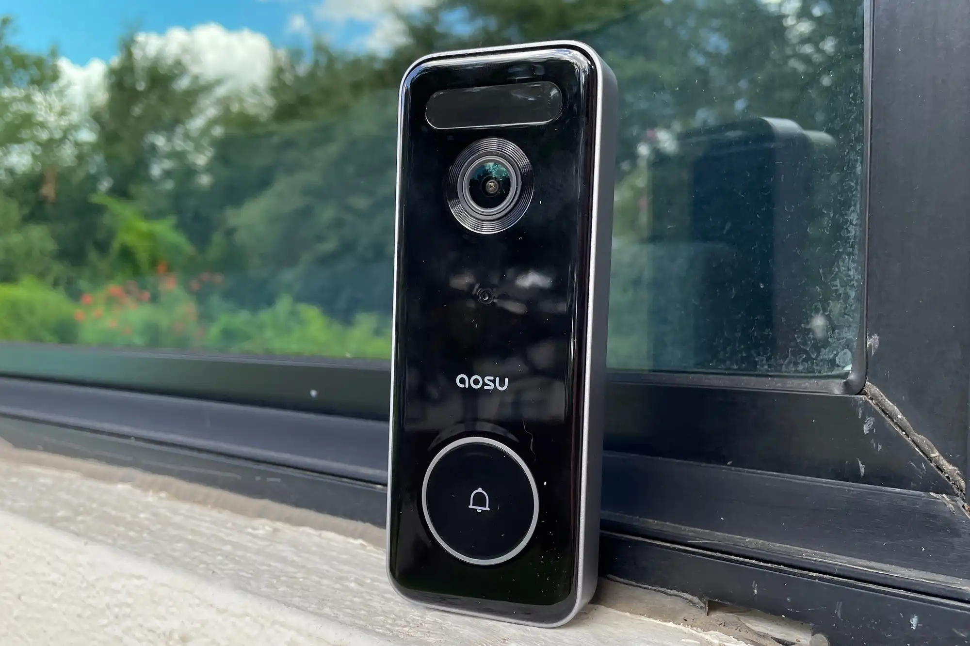 AOSU Wireless Doorbell Camera installed on a modern front door, showing its compact and weatherproof design.