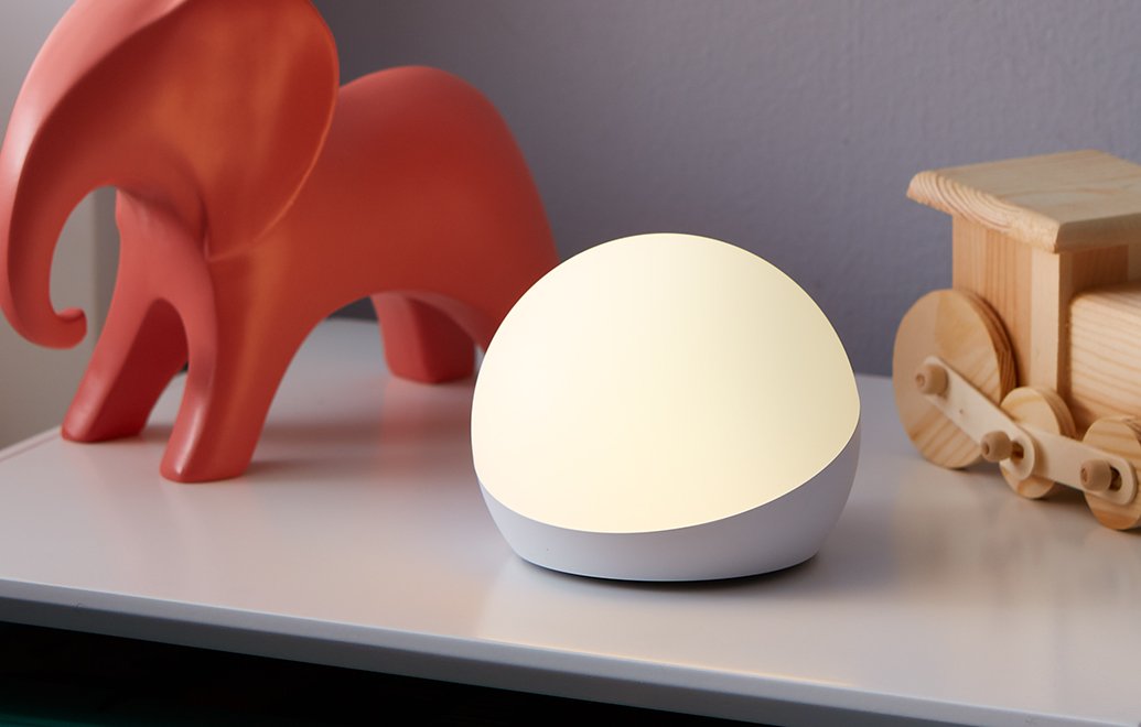 The Echo Glow smart lamp providing a soft, colorful nightlight glow in a child's bedroom.