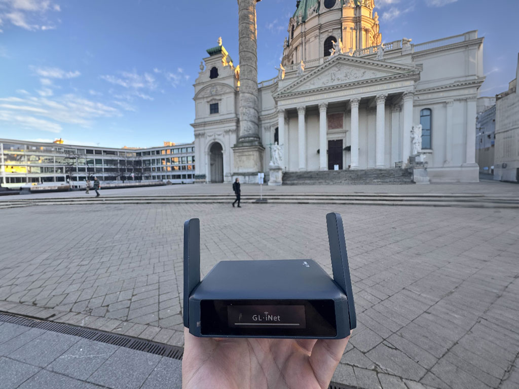 The compact GL.iNet Slate 7 Wi-Fi 7 travel router in a modern café setting.