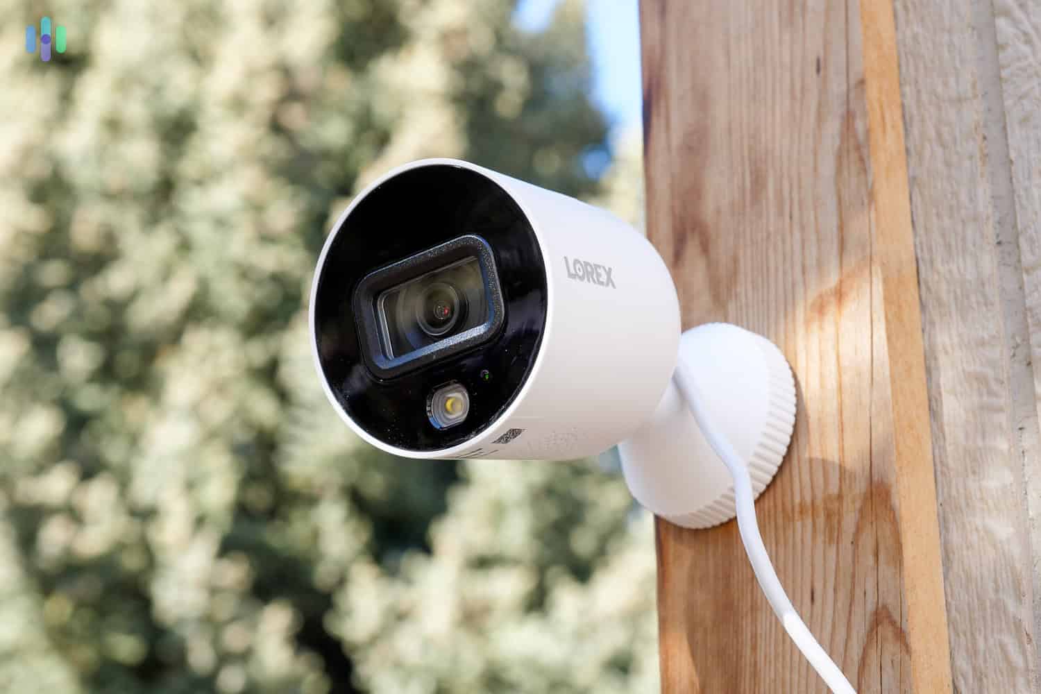 A modern outdoor security camera installed under the eave of a house.